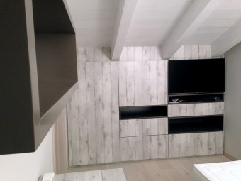 CAMERA TERZO FIGLIO. Pavimento in parquet Spazzolato Rovere Argento. Soffitto con travi a vista. Arredamento personalizzato (BEZUS - LPL). Sedia imbottita con rivestimento in ecopelle (DOIMO).
