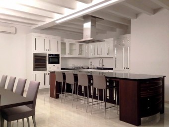 CUCINA - SALA DA PRANZO. Pavimento in gres porcellanato. Soffitto con travi a vista. Arredamento personalizzato (BEZUS - LPL). Tavolo da pranzo in rovere tabacco con le gambe in metallo effetto bronzo (MINOTTI). Sedie rivestite in tessuto (MINOTTI). Sgabelli (ZANOTTA).