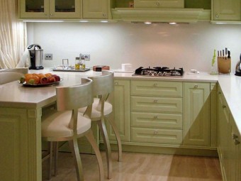 CUCINA realizzata internamente in multistrato pioppo rivestito con laminato bianco. Ante, cornicione perimetrale sopra pensili, zoccolino e cappa sono realizzati in laccato opaco. Top e alzata in Corian.