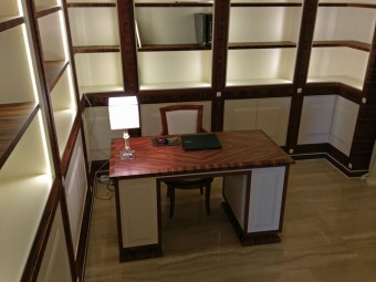 LIBRERIA realizzata in combinazione di due materiali: essenza di Palissandro Santos e legno laccato opaco, composta da ripiani spostabili e vani con ante, illuminata con luci LED.